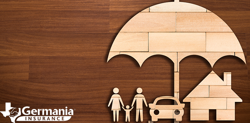 A wooden cutout depicting umbrella insurance covering a family, auto, and home