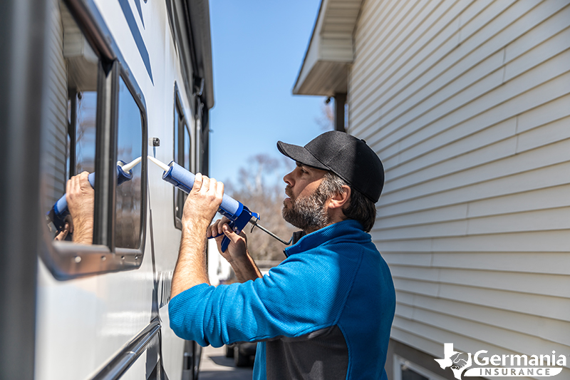 A man caulking windows, performing essential RV maintenance