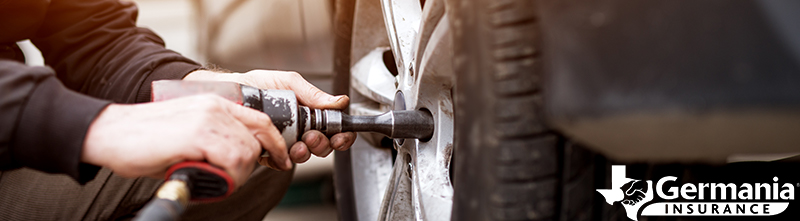 A man performing essential tire maintenance by rotating tires