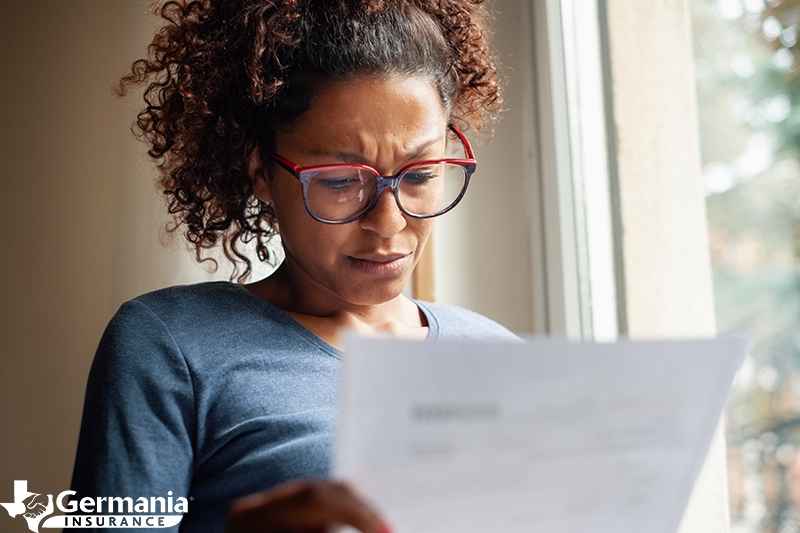A concerned woman looking at a bill that might indicate deed theft scams