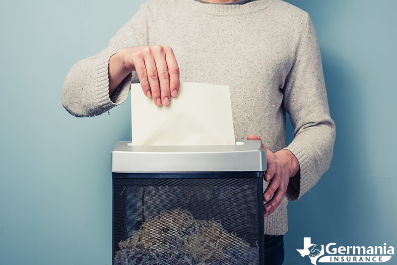 A man destroying sensitive documents with a shredder