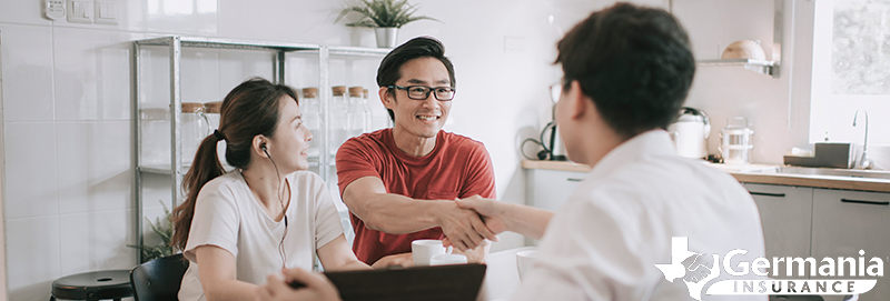 A couple shaking hands with an insurance agent