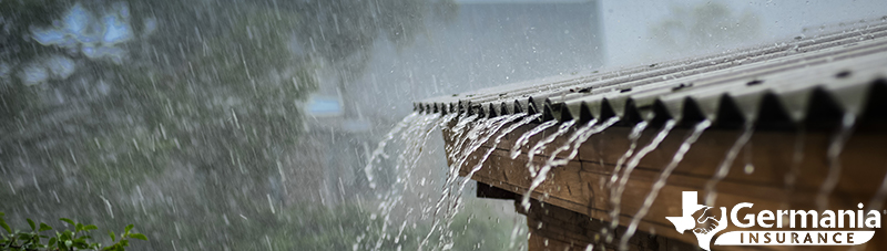 Rain falling down roof shingles on a home prepared for hurricane season. 