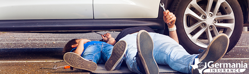 A father and child under a vehicle, performing routine auto maintenance