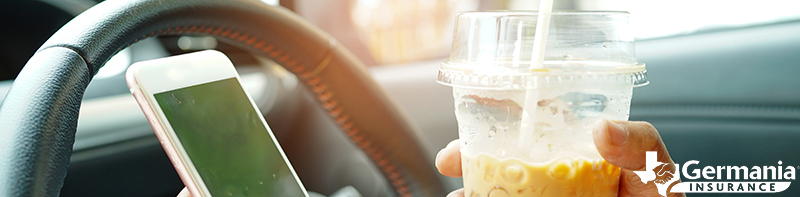 Hands holding a phone and a drink, common kinds of distracted driving