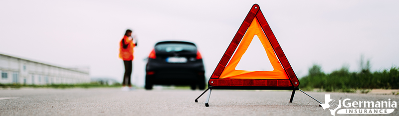 An emergency triangle behind a car that has broken down.