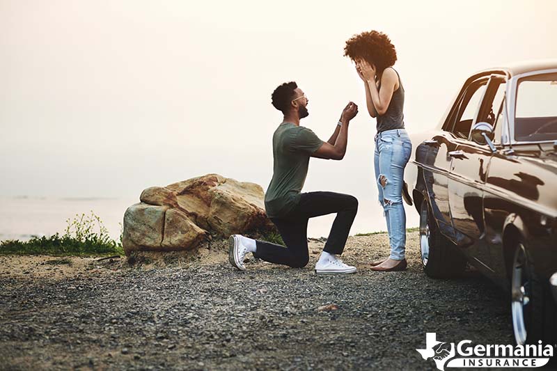 A man on one knee asking a woman to join him in marriage