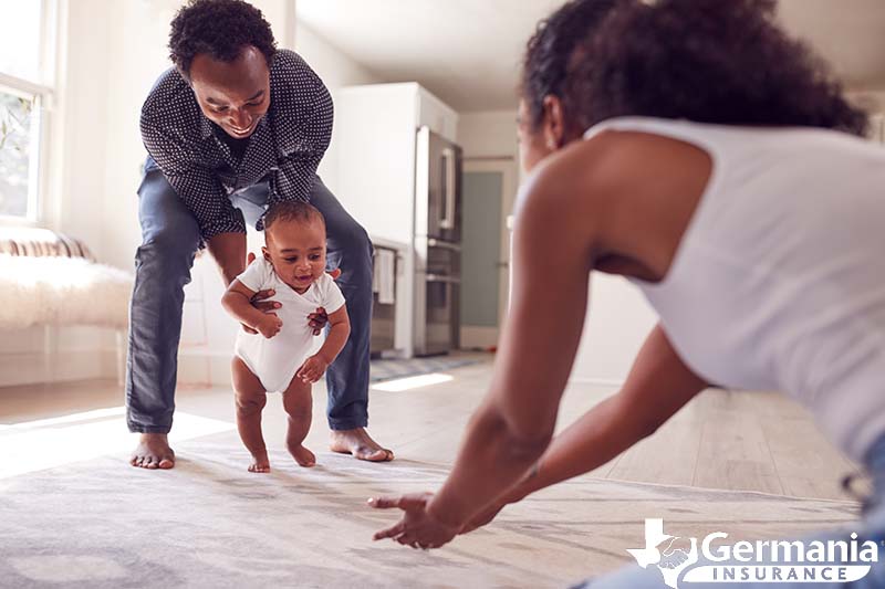 A mother and father teaching a child to walk