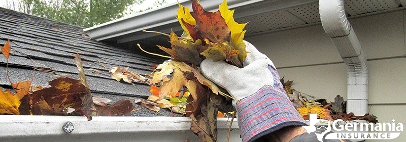 Cleaning leaves from a gutter to protect against wildfires
